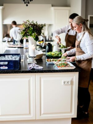 Chefs in a modern kitchen preparing dishes with precision and teamwork, highlighting culinary expertise and professionalism.