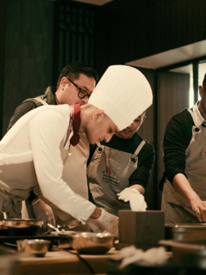 Team of chefs working together in a modern restaurant kitchen, preparing gourmet dishes with precision and skill.